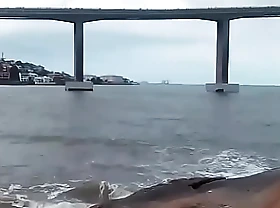 Exibindo em frente a ponte na praia